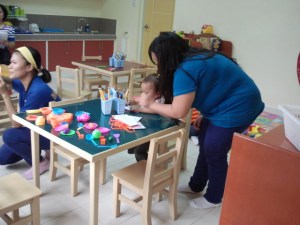Ria started to use the pencils and crayons inside the classroom with her favorite teacher