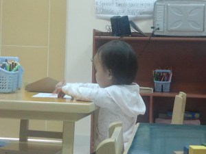 doing her work..without the help of her teacher.  Good job! :)